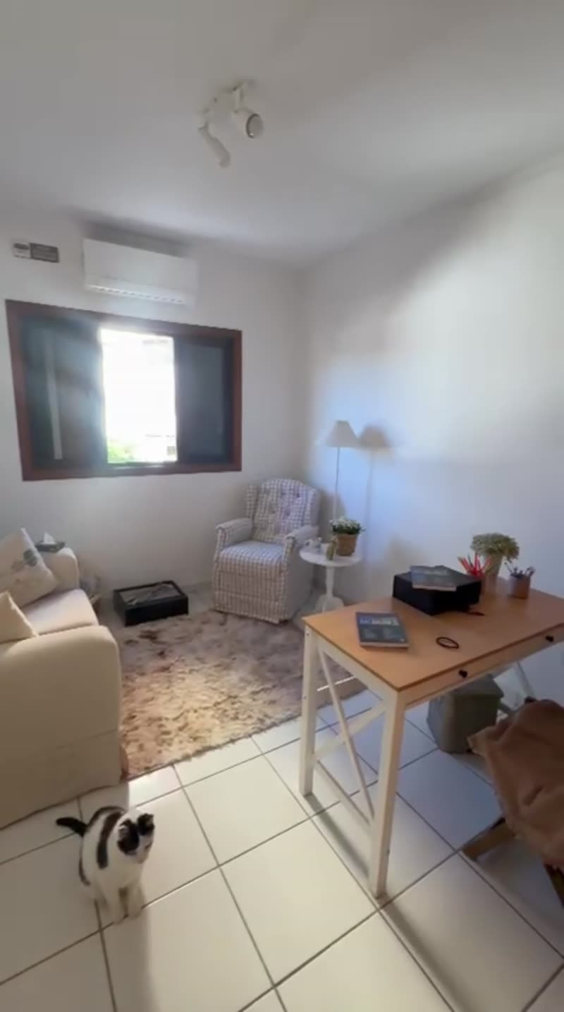 Sala de atendimento iluminada pela luz natural, com poltrona, mesa e janela